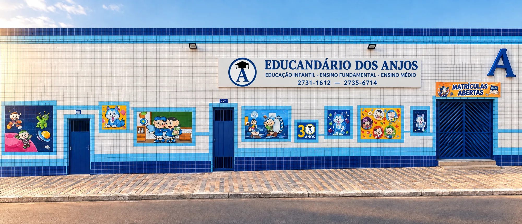 Fachada do Educandário dos Anjos: parede de azulejos brancos com faixas azuis, murais coloridos e a placa da escola
